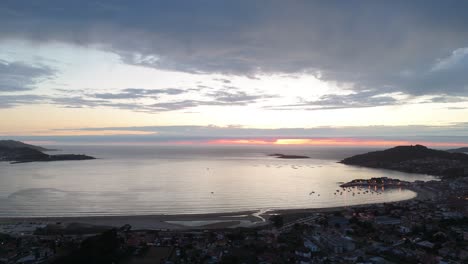 aerial sunset view over baiona's playa américa, spain, with glowing horizon and calm sea waters