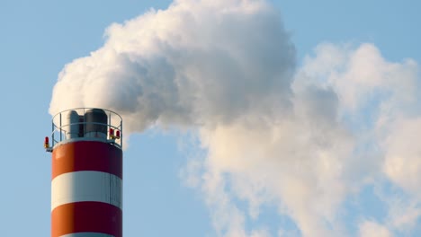 white smoke air pollution coming from the pipes on an industrial factory