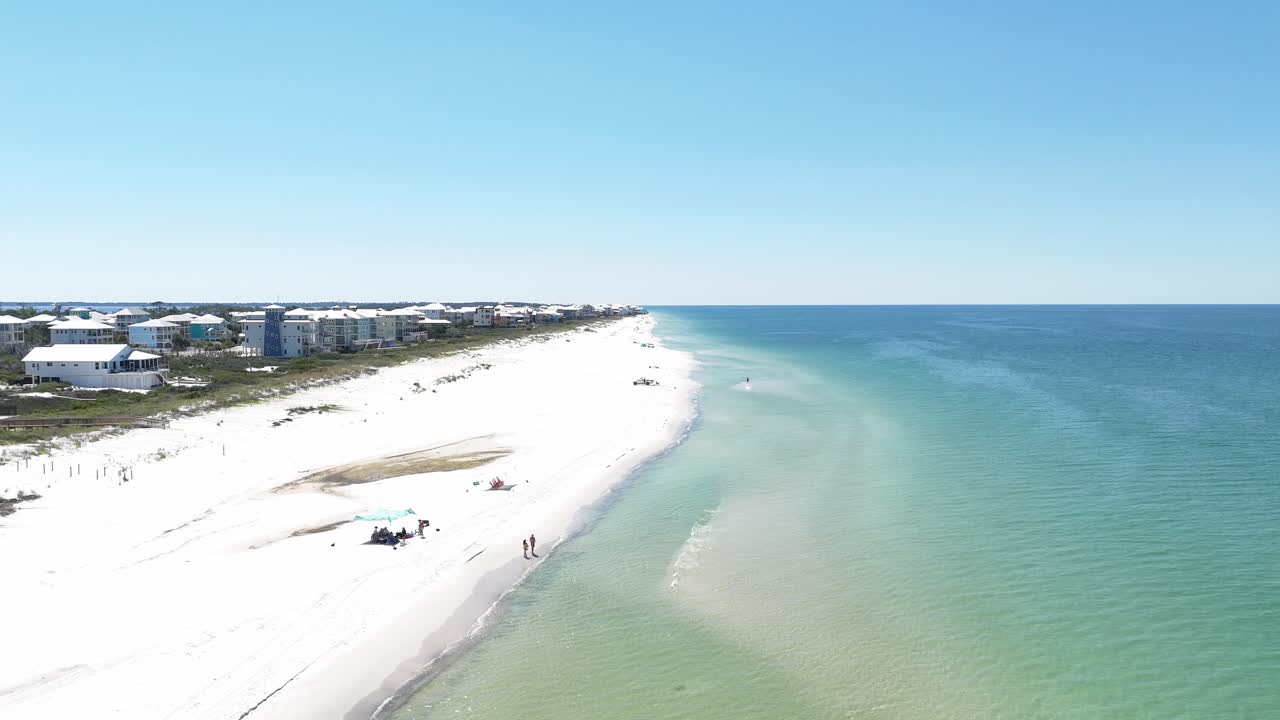 Forward drone movement over the wide sandy beach side of Cape San Blas with turquoise ocean, Gulf County, Florida, USA
