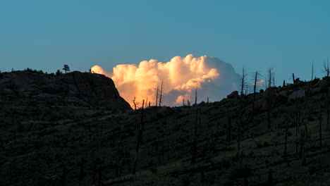 curious billowing cloud formation behind mountain, sunset timelapse