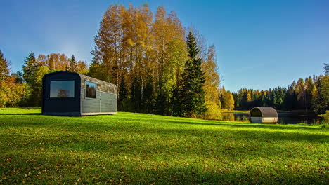 vivid fall colors in tree foliage around tiny house on lake