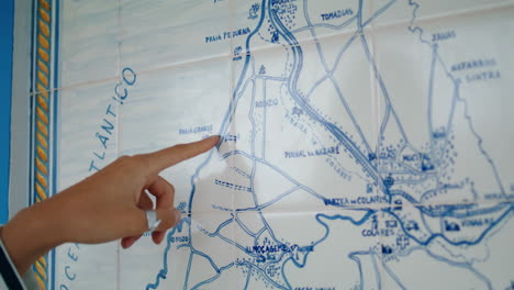 closeup finger pointing map looking trip direction. lost tourist planning route