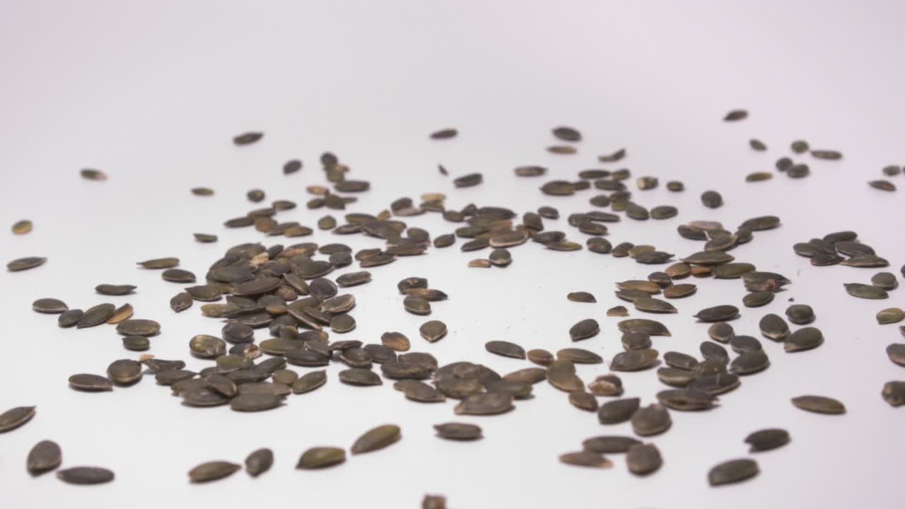 흰색 표면에 떨어지는 호박 씨앗