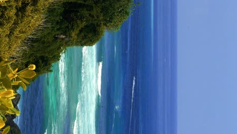 Vertical-Slow-motion-handheld-shot-of-the-cliffs-at-Suluban-Beach-overlooking-the-blue-sea-on-a-beautiful-summer-day-on-the-trip