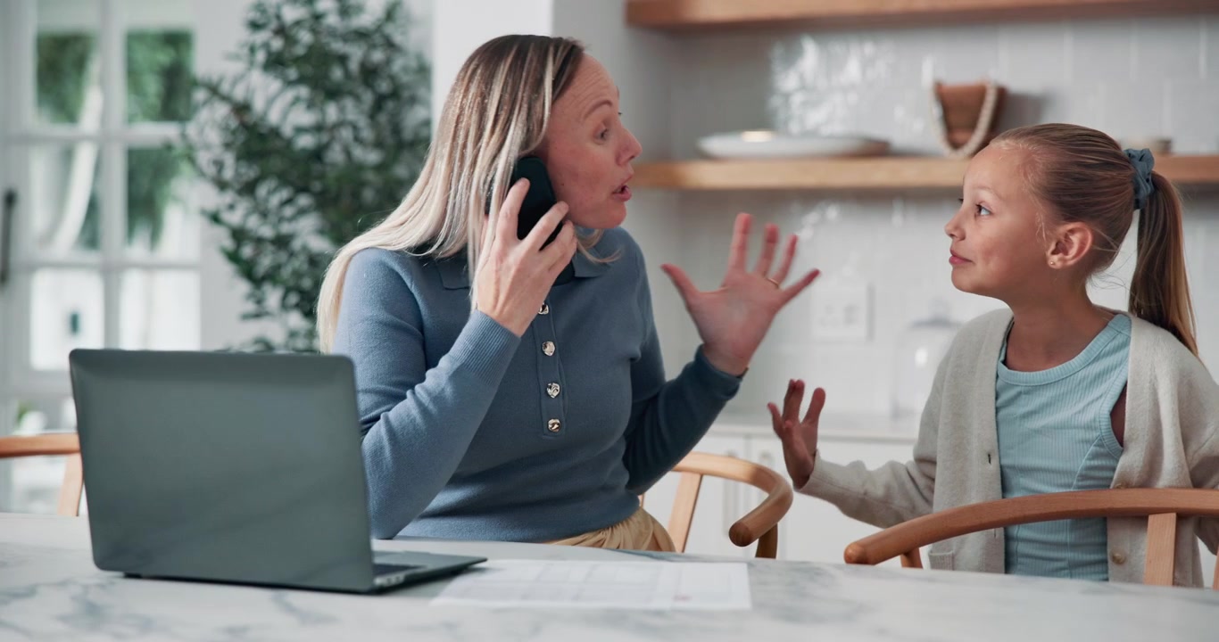 Stressed Mother Working from Home While Daughter Interrupts