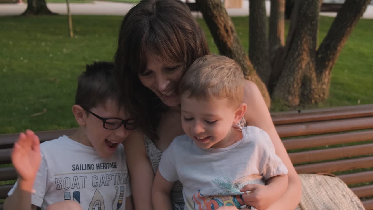 Caucasian mother and sons enjoy family entertainment on smartphone app