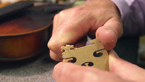 man restoring violin in workshop