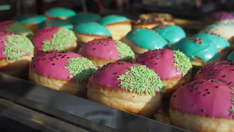 a close-up shot of pink and blue donuts with sprinkles