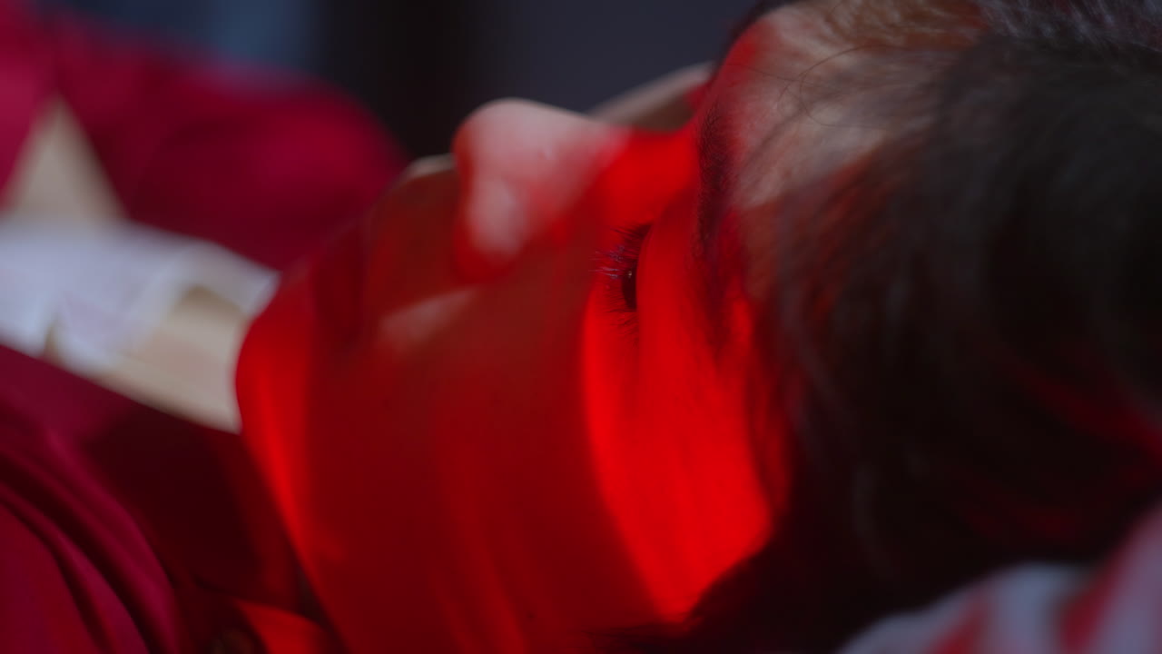 Close-up of a Person's Face Illuminated by Red Light