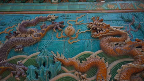 dragons sculpture on blue wall in the nine dragons wall at beihai park, beijing