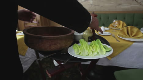 el chef preparando una ensalada césar en un restaurante.