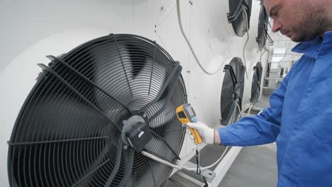 technician uses a thermal imaging infrared thermometer to check the condensing unit heat exchanger