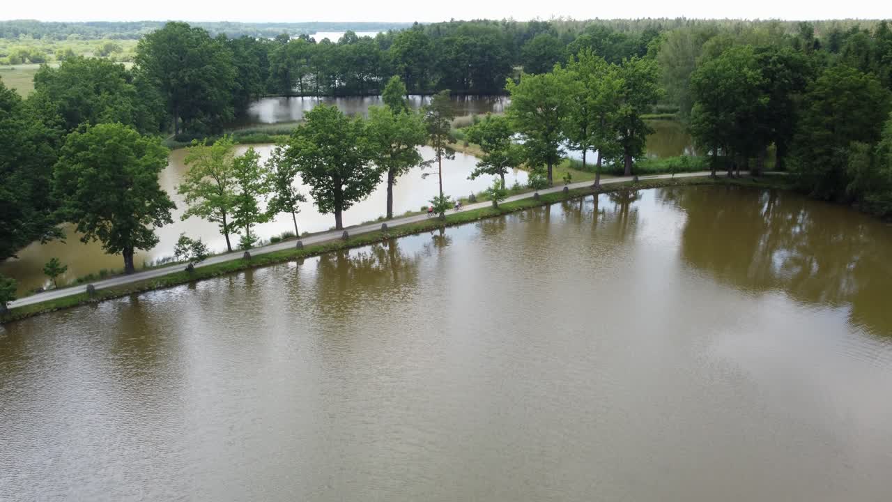 grupo de ciclistas que pasan por la presa de dos estanques