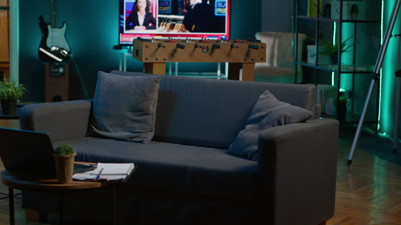 Cozy modern apartment decorated with neon lights and a big tv, home theatre and setup for a young adult. Empty loft studio illuminated and equipped with electronics, comfortable space.