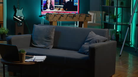 cozy modern apartment decorated with neon lights and a big tv, home theatre and setup for a young adult. empty loft studio illuminated and equipped with electronics, comfortable space.
