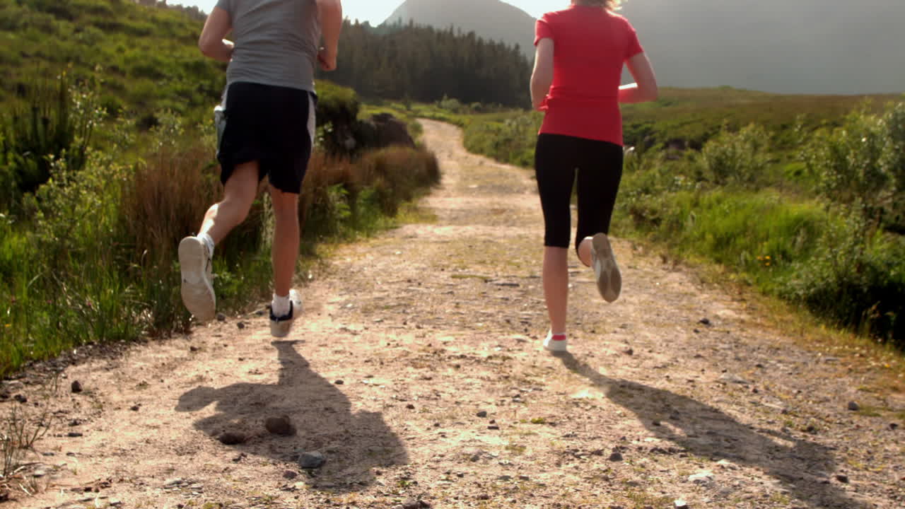pareja en forma corriendo juntos en el campo lejos de la cámara