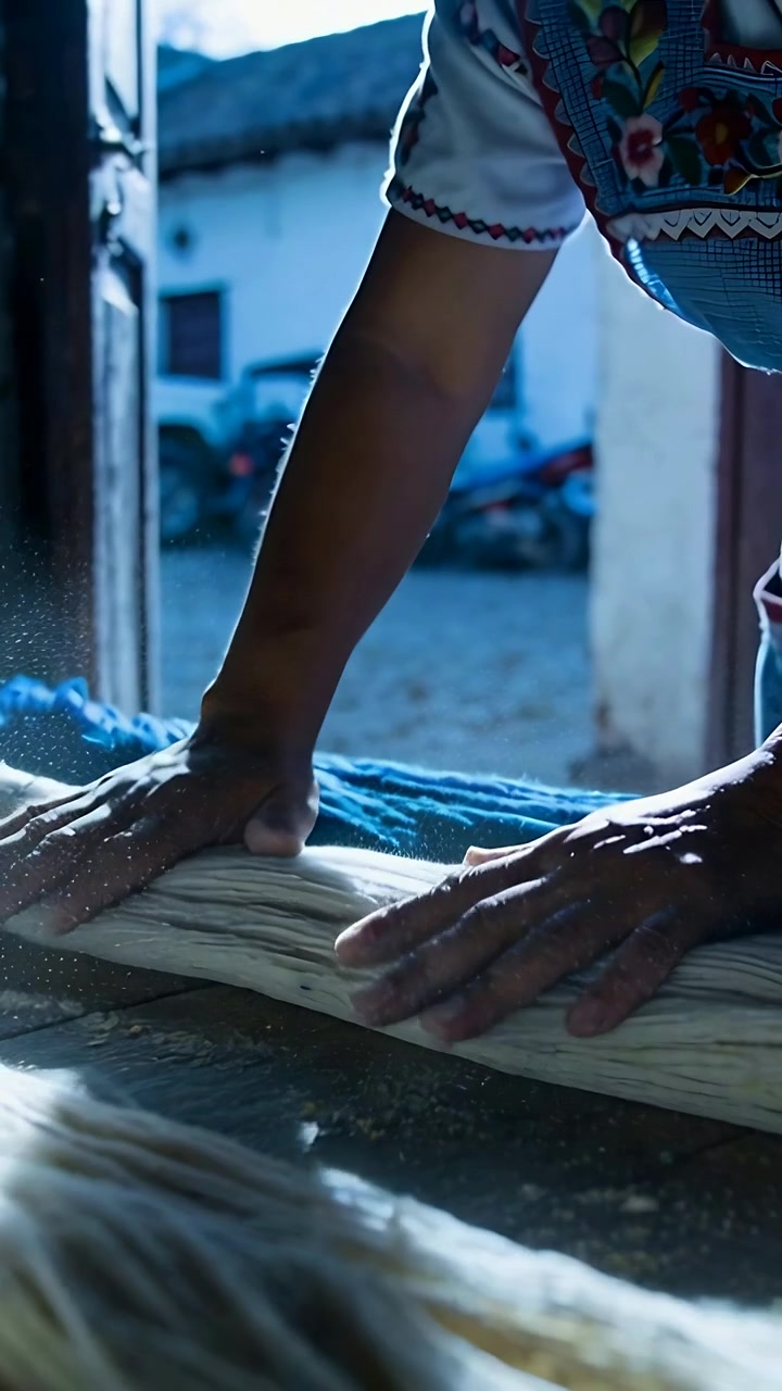 Vertical video: Entering artisan hands pressing and smoothing fibers at doorway for yarn