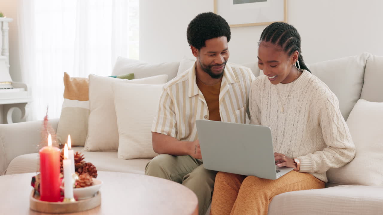 Couple using laptop on a couch during Christmas