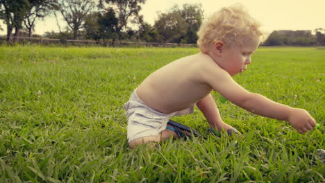 baby boy blowing soap bubbles outdoors