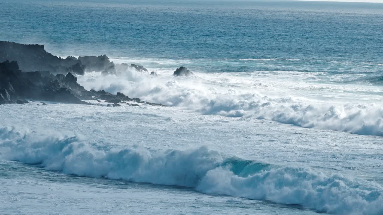 Dramatic ocean waves collide with the volcanic coastline near Timanfaya National Park, located on the island of Lanzarote in the Canary Islands, Spain.