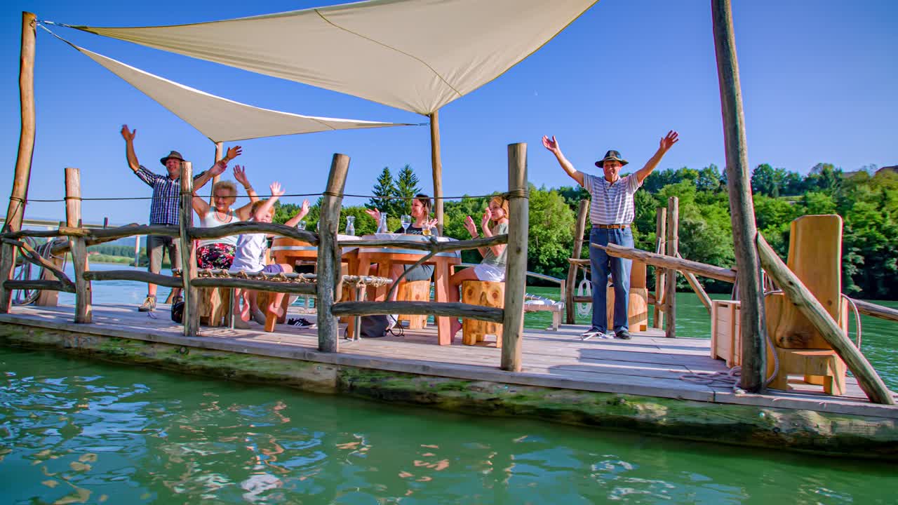 aerial arc shot of family enjoying the timber log raft experience, Drava river