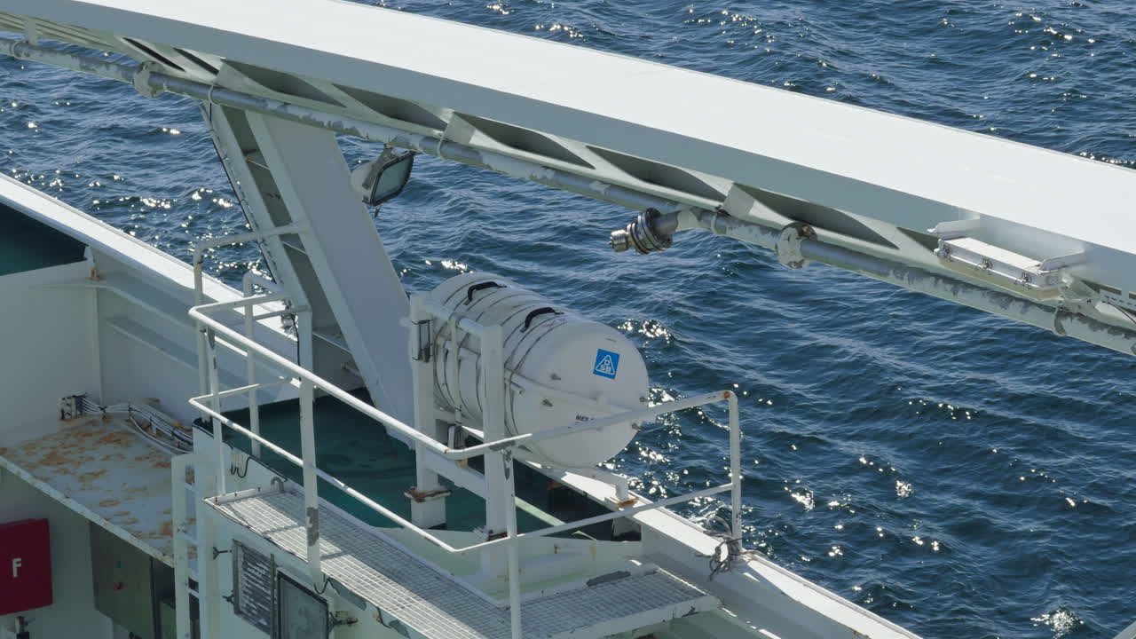 Close-up of a ship's deck with life raft and other equipment