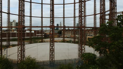 Drohnenaufnahmen-Des-Viktorianischen-Gasspeichers-In-Bethnal-Green-Mit-Der-Skyline-Von-London-Im-Hintergrund-An-Bewölkten-Tagen