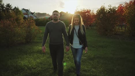 una pareja caminando en un parque al atardecer