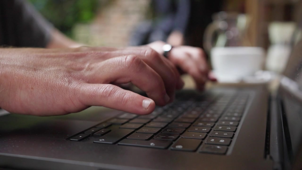 Person working at laptop, close up of hands typing, business workspace