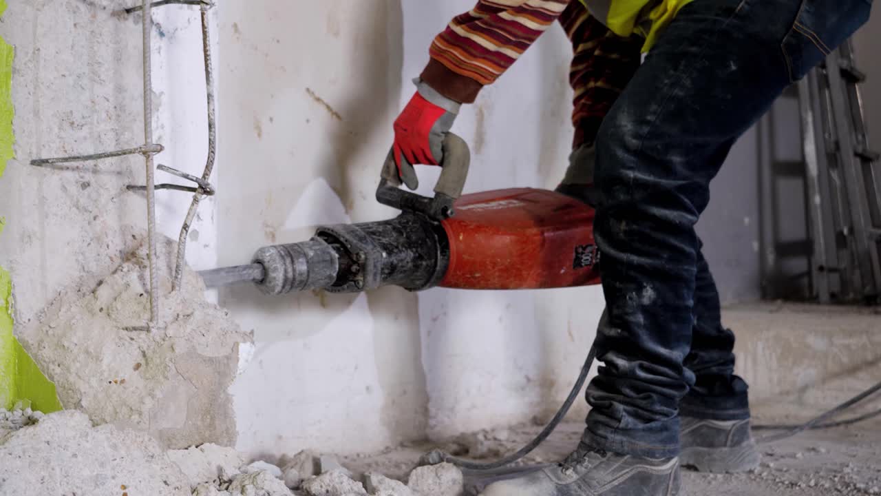 un hombre usa un martillo neumático sobre concreto para romperlo
