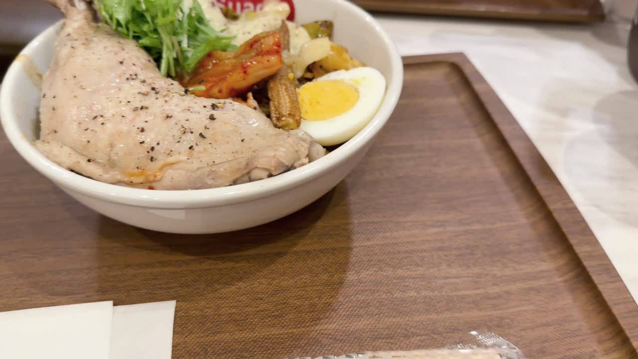 A wooden tray holding a bowl of Japanese soup curry is placed on a table