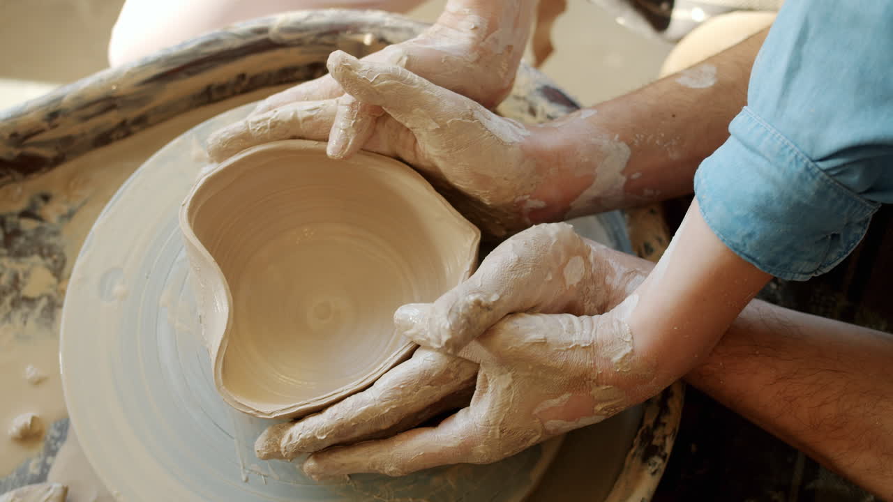 Mani che modellano una ciotola di argilla su una ruota di ceramica
