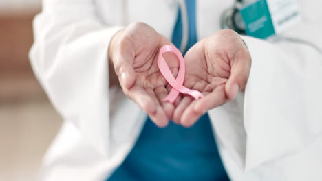 manos, médicos y una cinta rosa para el cáncer de mama