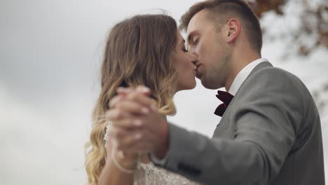 Lovely-caucasian-wedding-newlyweds-family-bride-groom-holding-hands,-making-a-kiss-on-mountain-slope