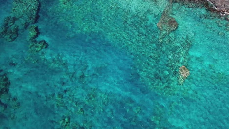 Agua-Azul-Cristalina-En-La-Isla-Grande,-Hawaii-Con-Rocas-Y-Texturas-Oceánicas