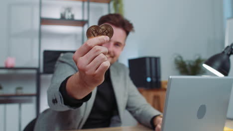 businessman stock trader earning count bitcoins after online monitoring trading operations at office