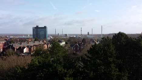 Luftbild-über-Parkbäume-Zum-Industriestadtbild-Mit-Blauem-Wolkenkratzer,-Merseyside,-England,-Dolly-Rechts