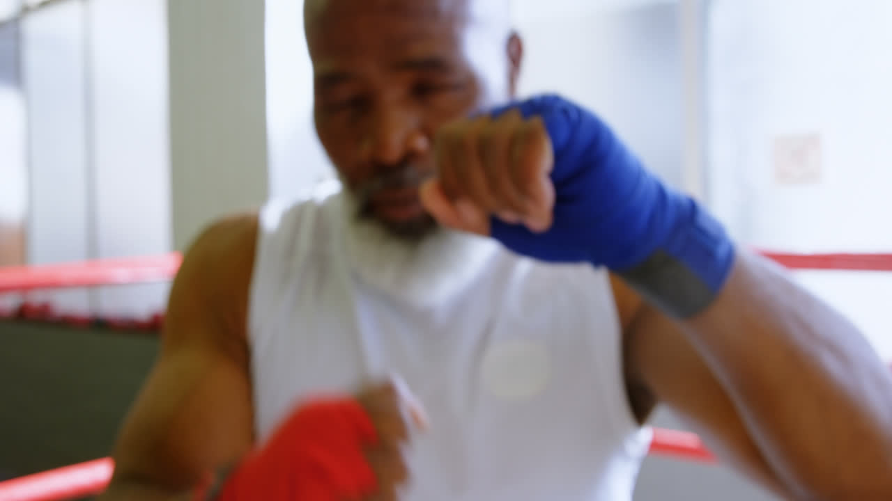 Senior man boxing in the fitness studio 4k