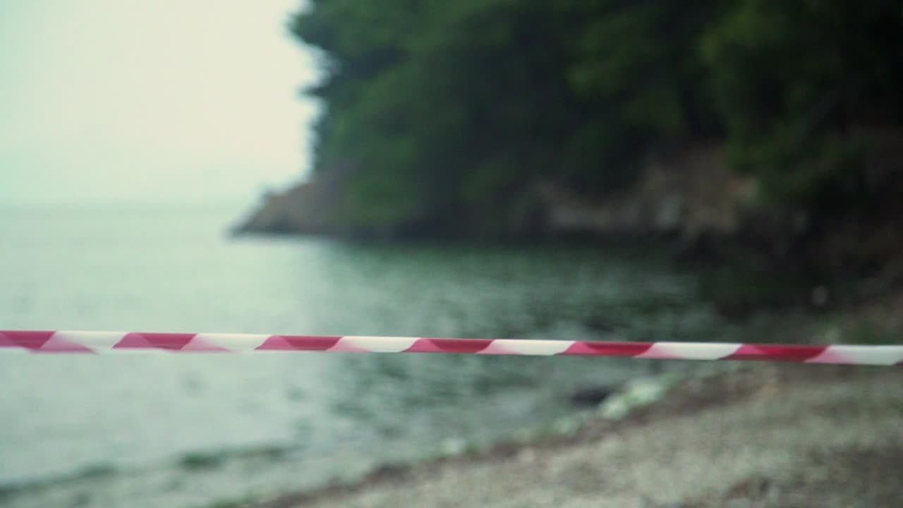 cordon red tape moving from strong wind at a beach , forbidden people going at sea COVID-19 pandemicCoronavirus disease 2019.