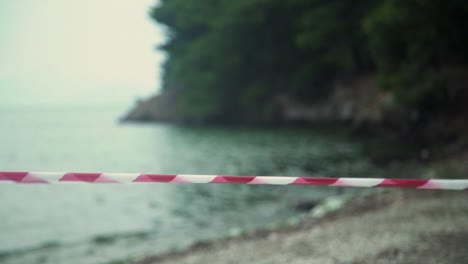 cordon red tape moving from strong wind at a beach , forbidden people going at sea covid-19 pandemiccoronavirus disease 2019.