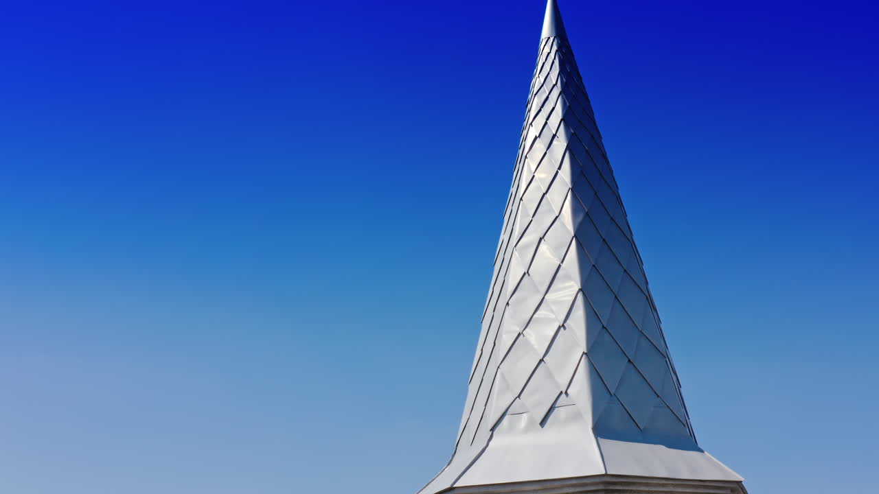 Facade of catholic church. Beautiful exterior of the catholic church with new windows on blue sky background. Close-up. Camera moving down.