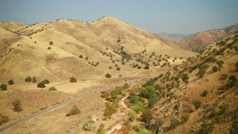 Un-Coche-Conduce-Por-Una-Carretera-Solitaria-En-Las-Praderas-Del-Desierto-Cerca-De-Caliente,-California---Vista-Aérea