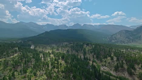 aerial view of expansive green valleys and distant mountain ranges under a clear blue sky