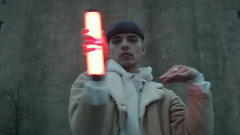 Man-Holding-Red-Light-Lamp-and-Dancing-Vogue-Outdoors