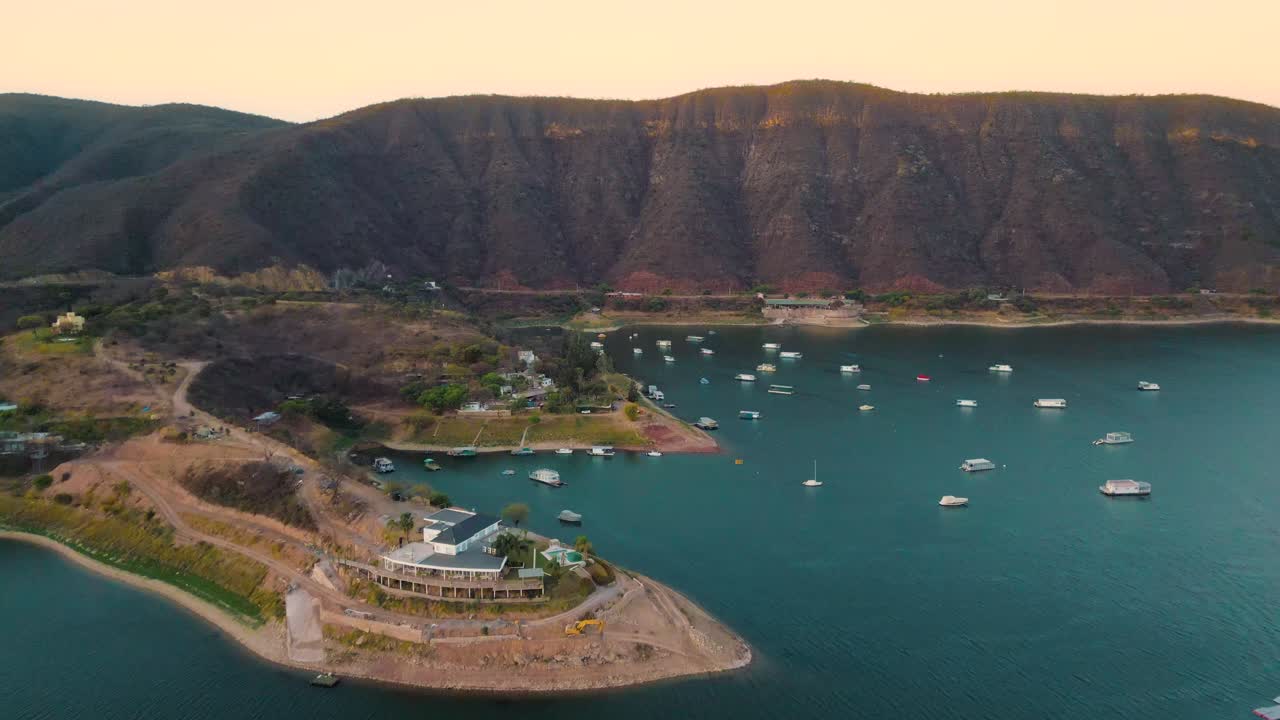 Vista aérea de un lago de montaña con barcos al atardecer
