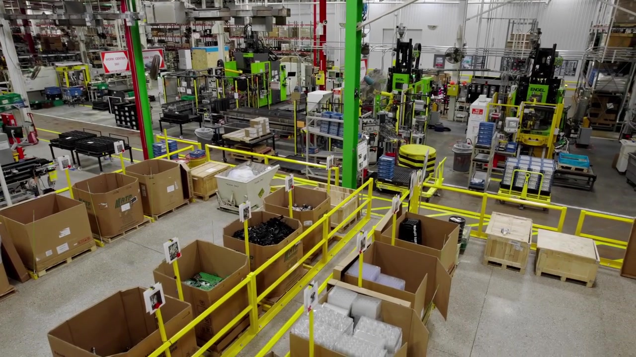 Wide panning view of boxes and equipment in large vehicle tech factory