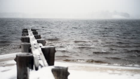 snow falls on a old wooden pier