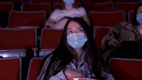 moviegoers in a theater wearing masks