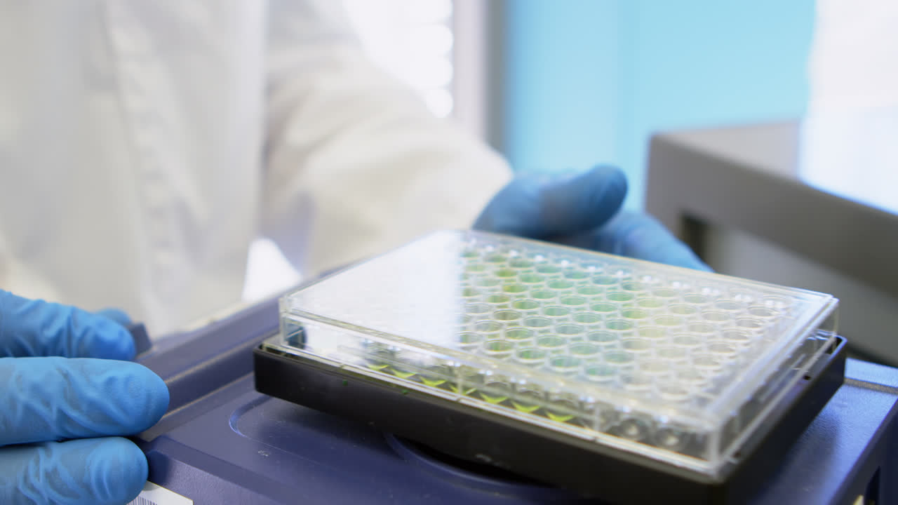 científico sacudiendo una microplaca en agitadores orbitales 4k