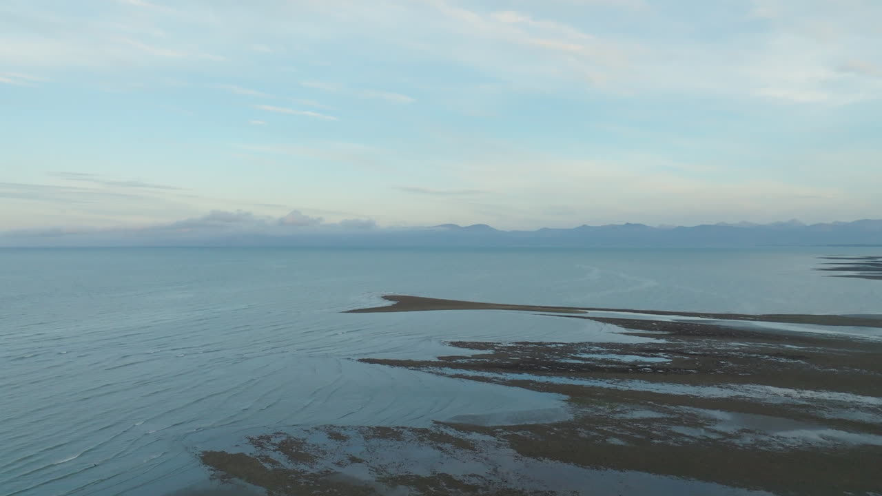 해변 해안선을 지나 멀리 있는 산을 향해 날아다니는 무인기, 타스만 지역, 뉴질랜드